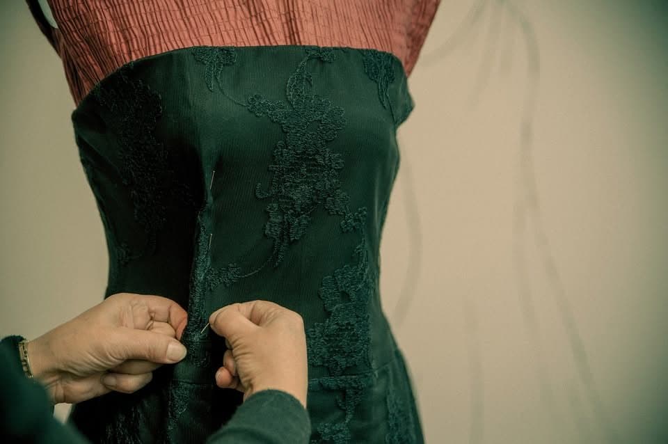 Mâini lucrând la o rochie neagră elegantă